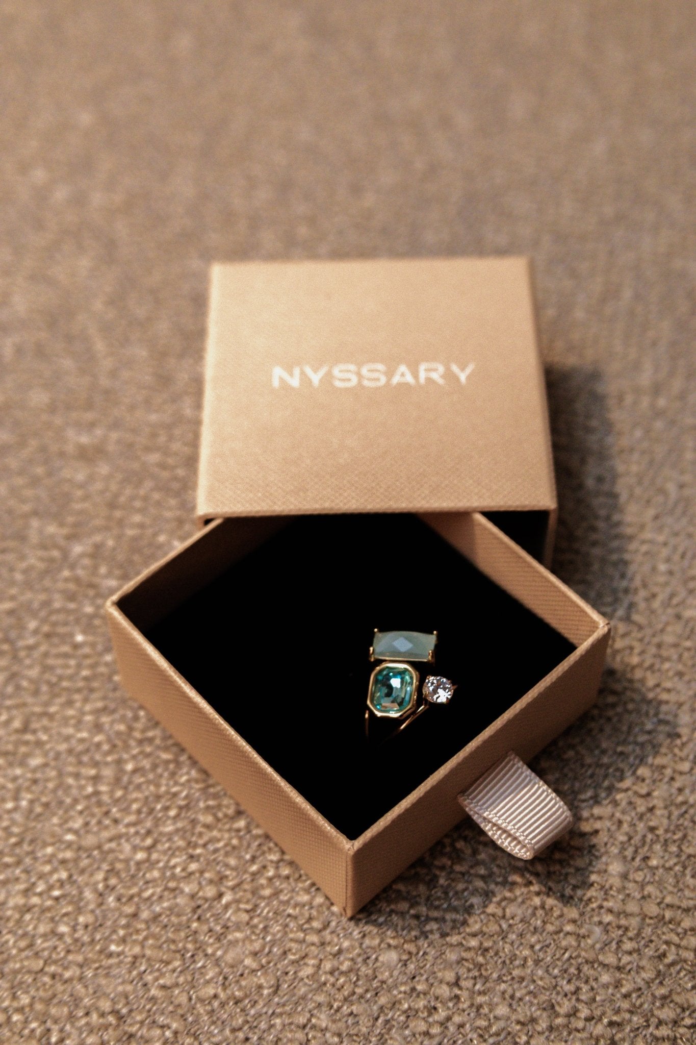 Bague acier inoxydable dorée présentée dans une boîte beige Nyssary