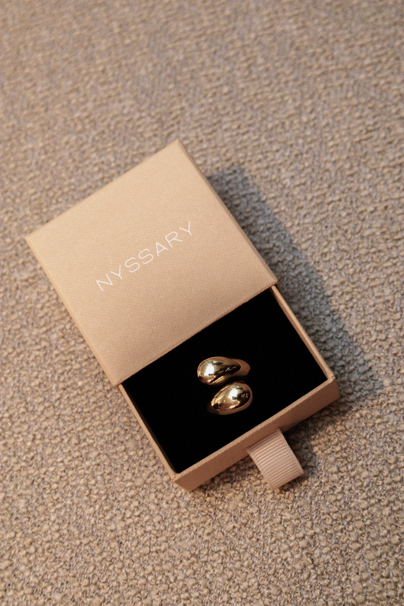 Bague acier inoxydable dorée présentée dans une boîte beige Nyssary