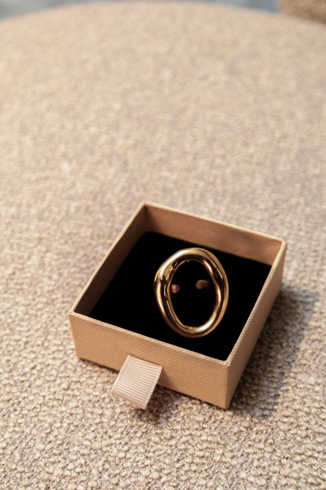Bague dorée présentée dans une boîte ouverte