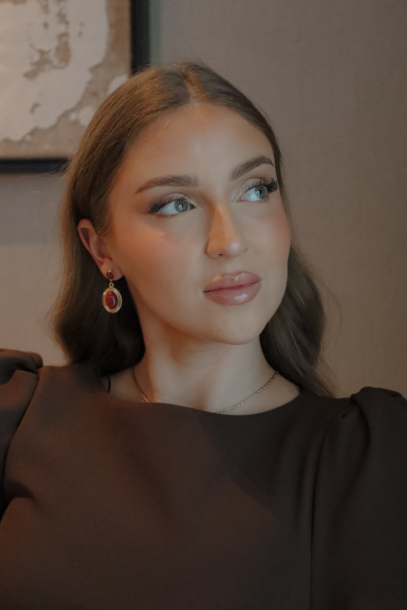 Gros plan sur le visage d’une femme mettant en valeur des boucles oreilles.