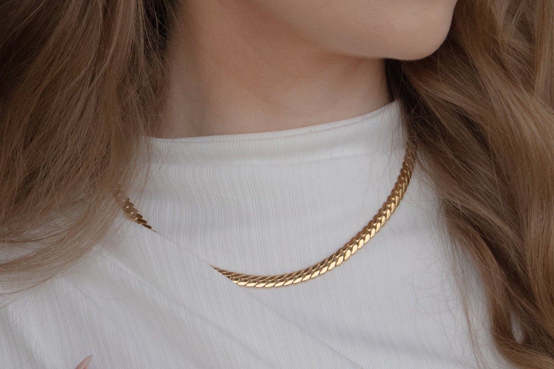 Zoom sur le cou portant un collier femme doré