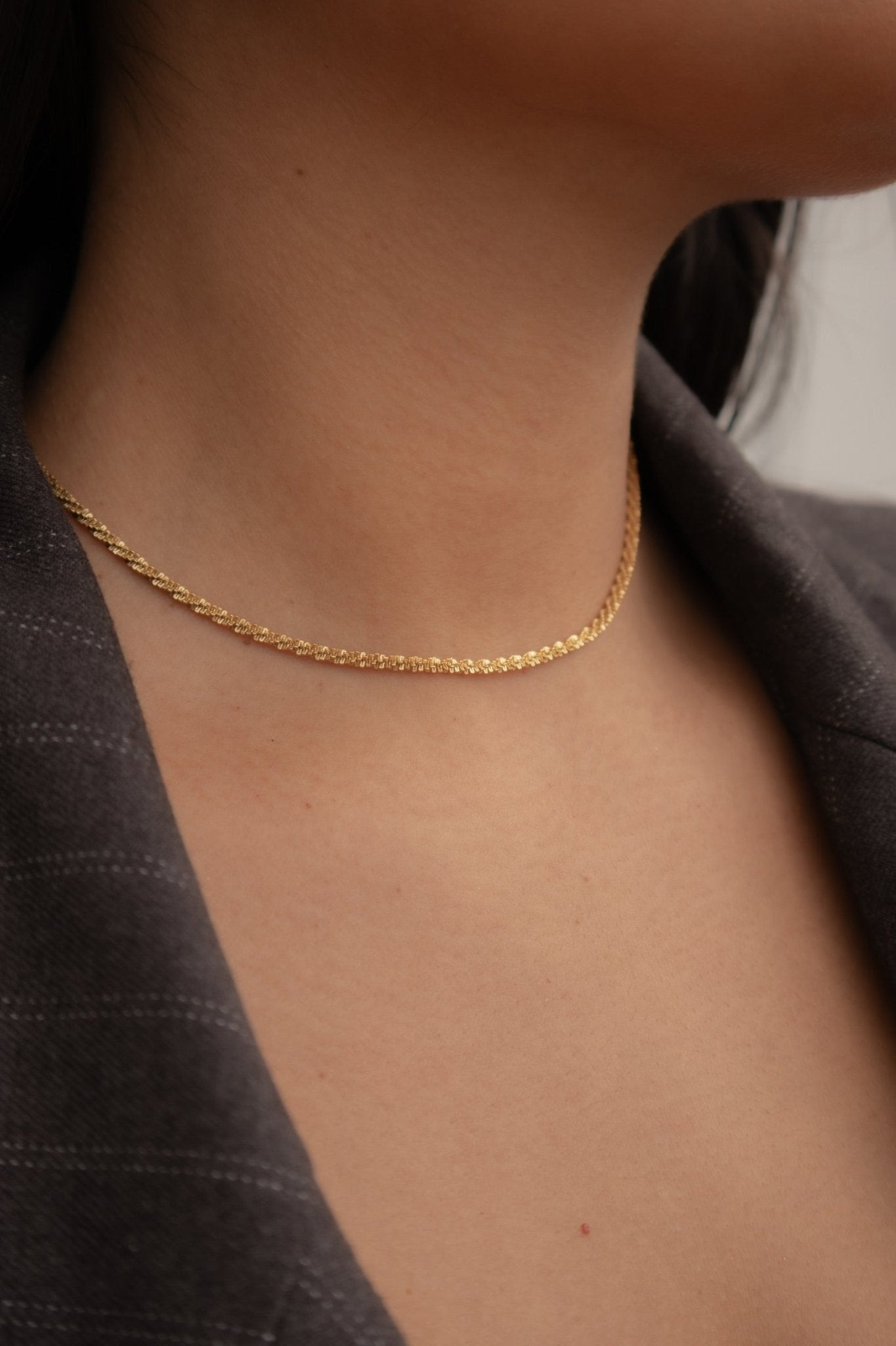 Collier doré Nira porté autour du cou